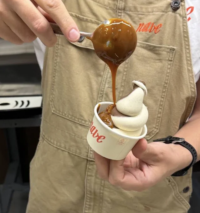 Caramelo cayendo sobre un helado soft en un vaso de Nave